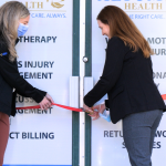 two people cutting a ribbon